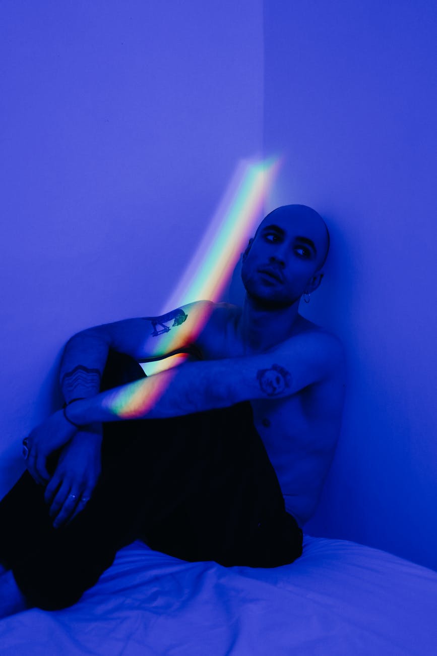man leaning on wall in blue light room